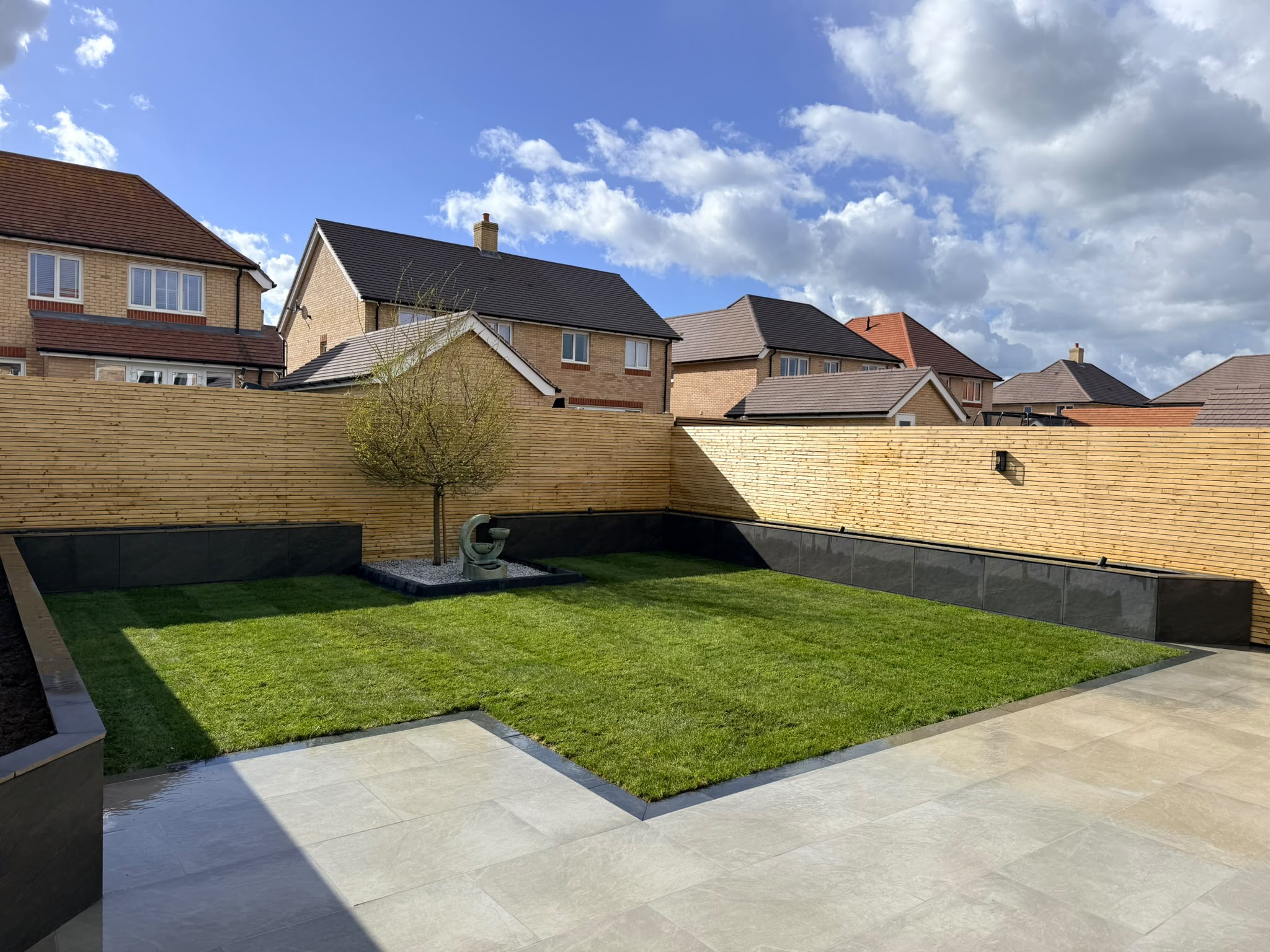 Porcelain patio, slatted fencing and feature tree on the Redrow estate, Witham