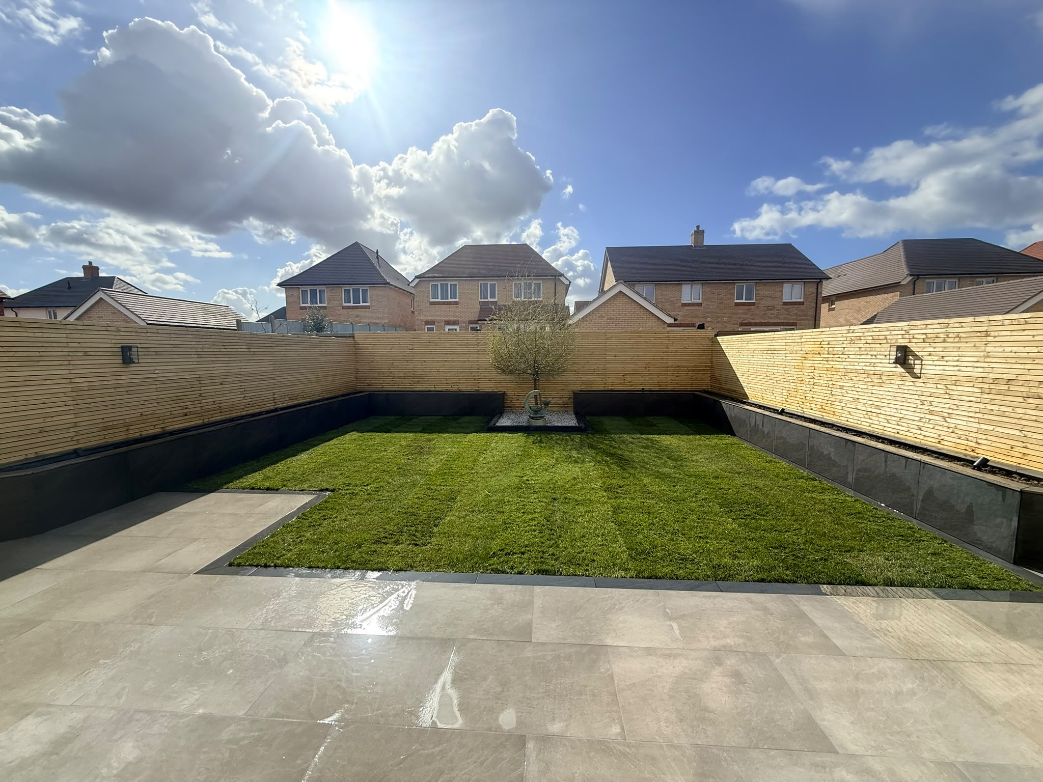 Wide porcelain patio and slatted fence boundary on the Redrow estate, Witham