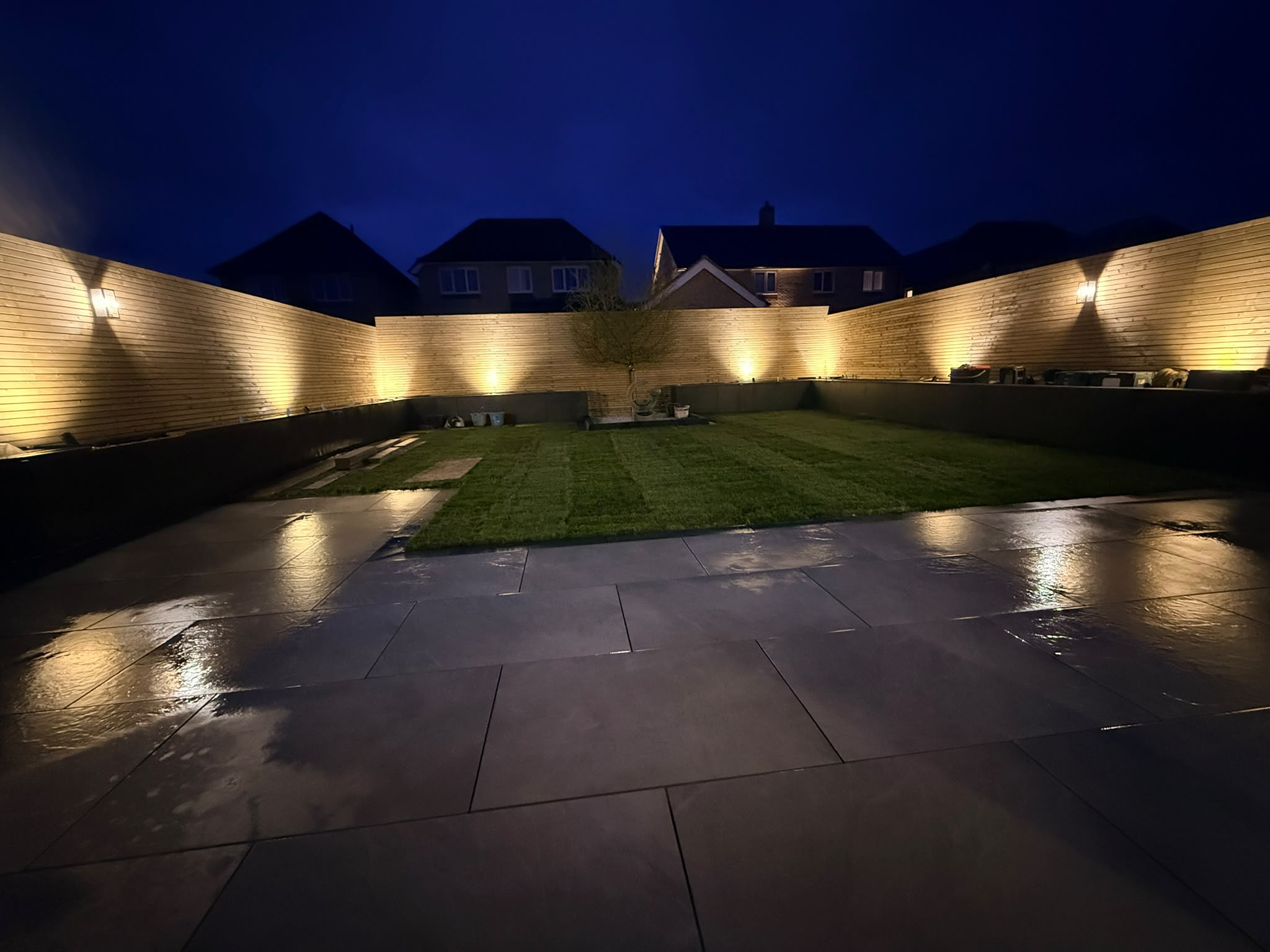 Integrated fence lighting illuminating the garden at night on the Redrow estate, Witham