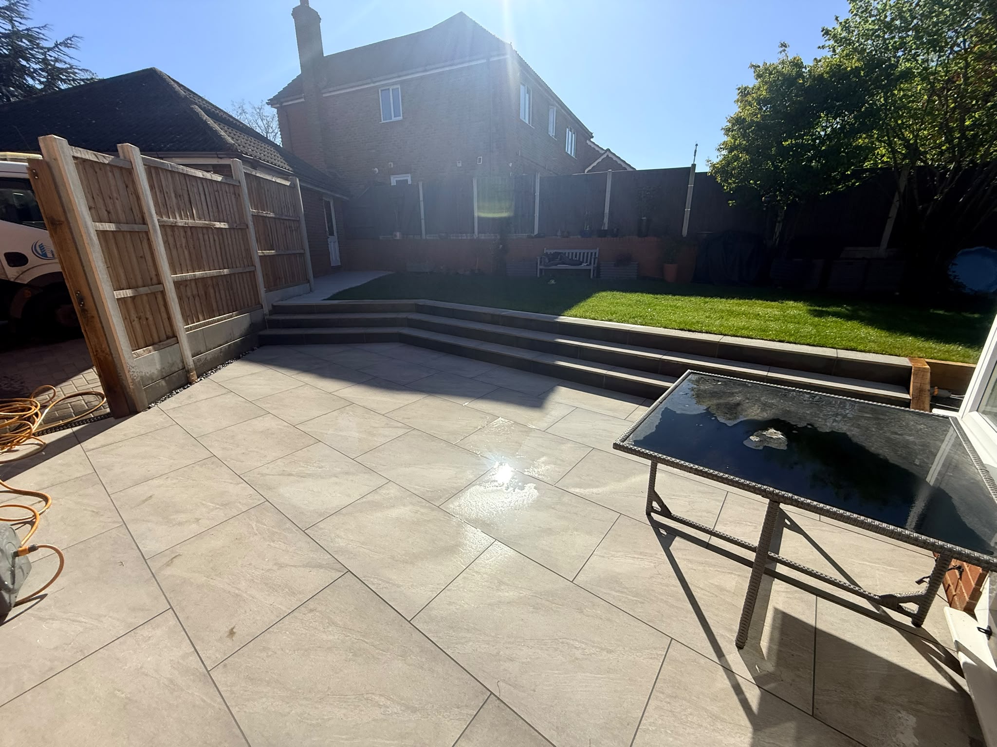 New porcelain patio with wide steps up to the lawn in Chelmsford